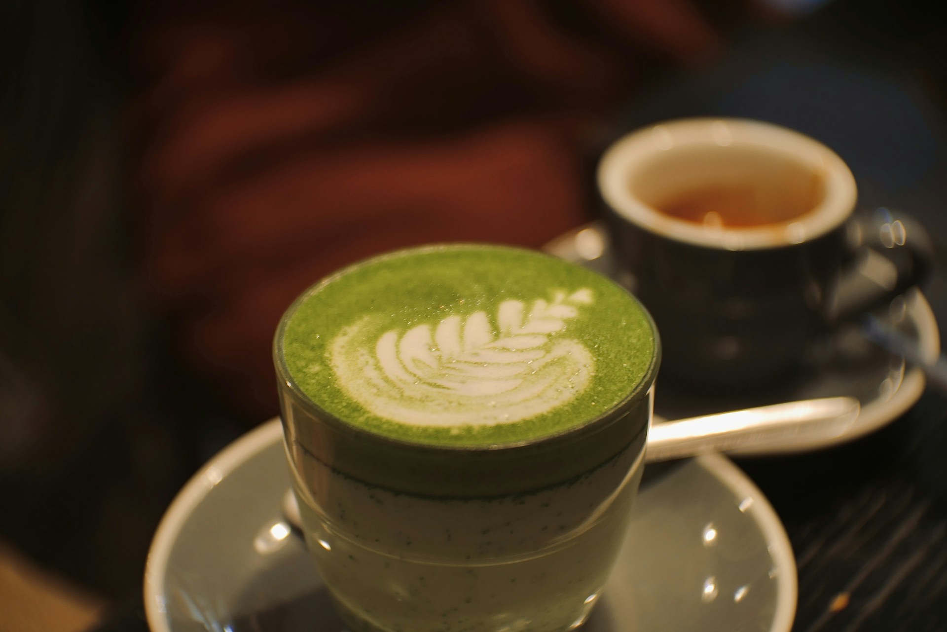 Cup of green tea with a leaf design on it